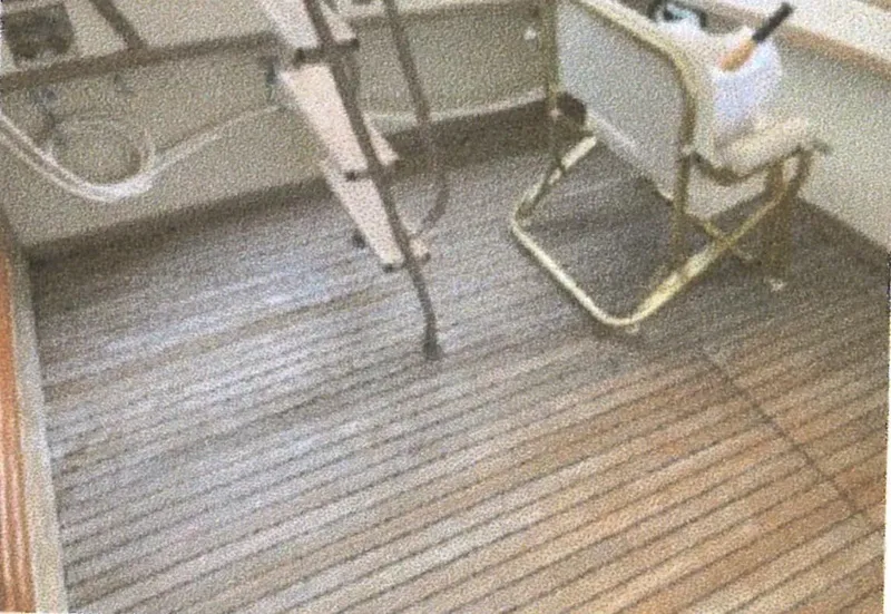 Slide: The Image of 1983 Egg Harbor 33 Convertible boat deck with wooden flooring and a folding chair. - 2