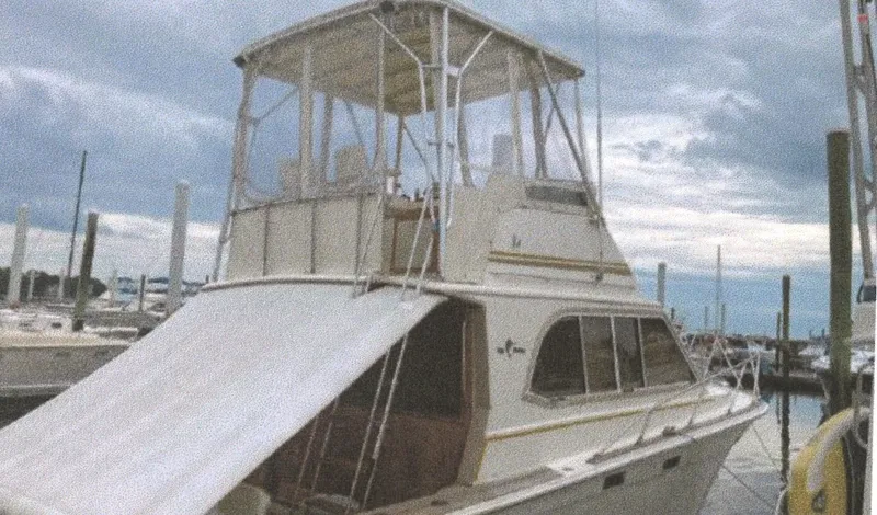 Slide: The Image of 1983 Egg Harbor 33 Convertible yacht docked at a marina under cloudy skies. - 3