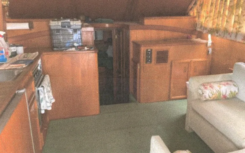 Slide: The Image of Interior of 1983 Egg Harbor 33 Convertible yacht with wood paneling and cozy seating area. - 7