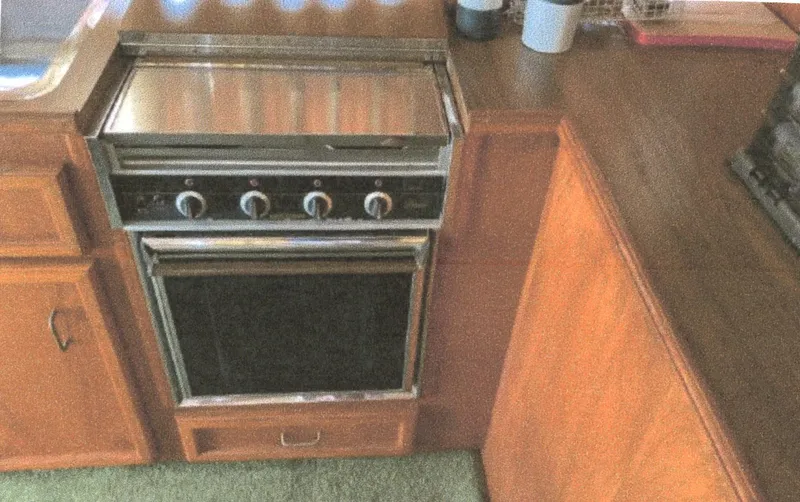Slide: The Image of 1983 Egg Harbor 33 Convertible kitchen with stove and wooden cabinetry. - 9