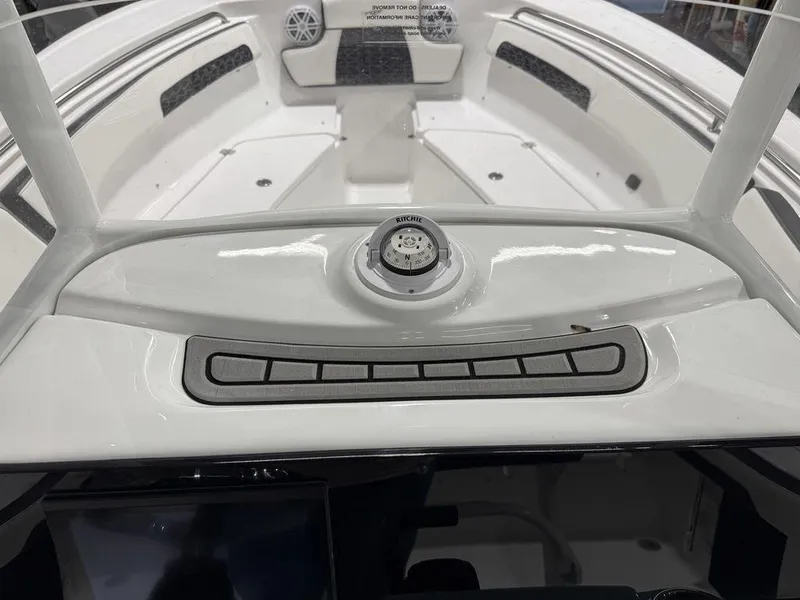 Slide: The Image of 2025 Tidewater 220 LXF boat dashboard with control panel and compass. - 25