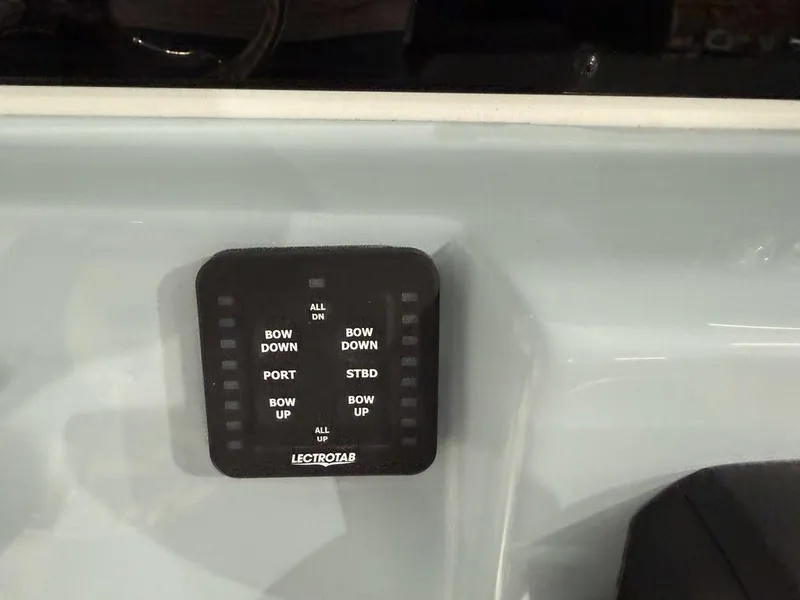 Slide: The Image of Tidewater 220 LXF 2025 boat control panel with Lectrotab trim tab switches. - 32