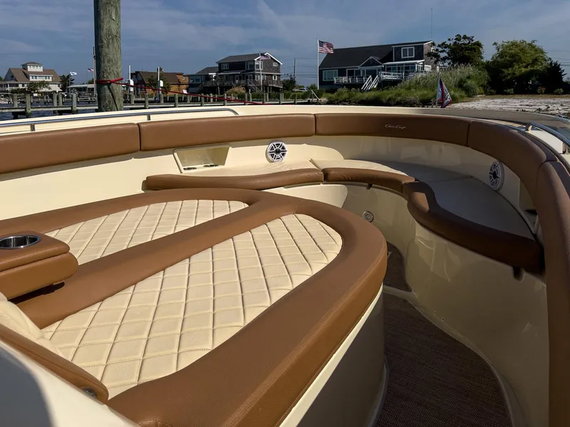 Slide: The Image of 2019 Chris-Craft 30 Catalina boat interior with tan leather seating and coastal background. - 15