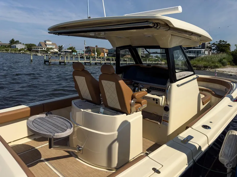 Slide: The Image of 2019 Chris-Craft 30 Catalina boat interior with seating and table, docked by the water. - 8
