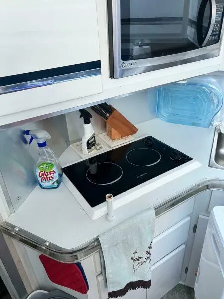 Slide: The Image of 1988 Wellcraft San Remo 43 yacht kitchen with stove, microwave, and cleaning supplies. - 10