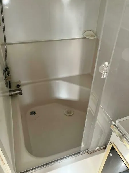 Slide: The Image of Bathroom interior of 1988 Wellcraft San Remo 43 yacht, featuring a compact shower area. - 16