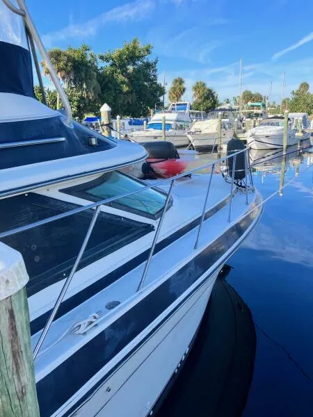 Slide: The Image of 1988 Wellcraft San Remo 43 yacht docked in a marina under clear blue skies. - 4