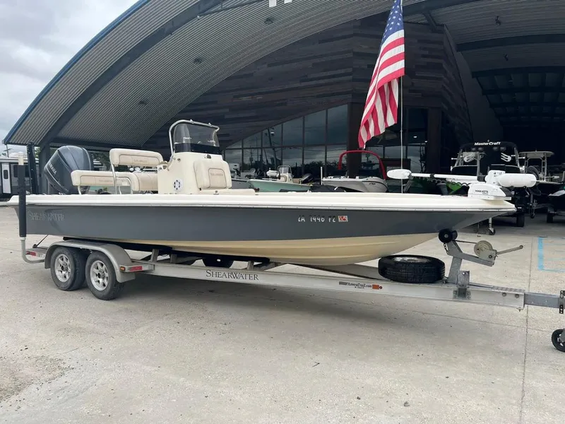 Slide: The Image of 2012 ShearWater 23LTZ boat on trailer with American flag in background. - 1