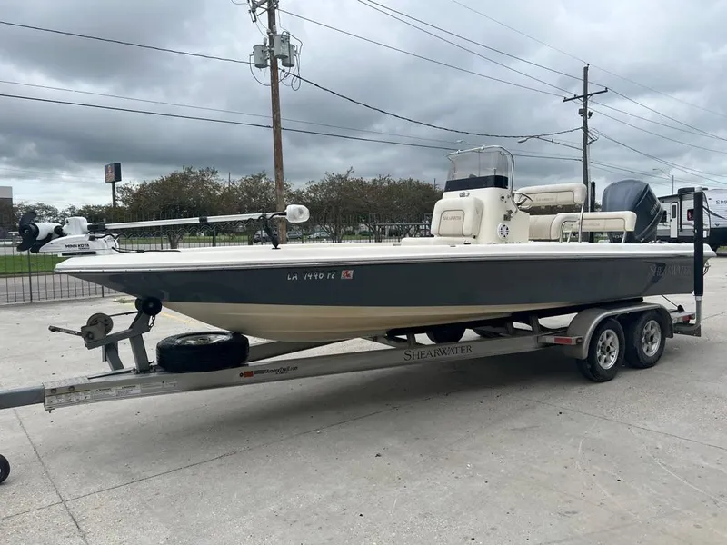 Slide: The Image of 2012 ShearWater 23LTZ boat on trailer, parked outdoors under cloudy sky. - 4