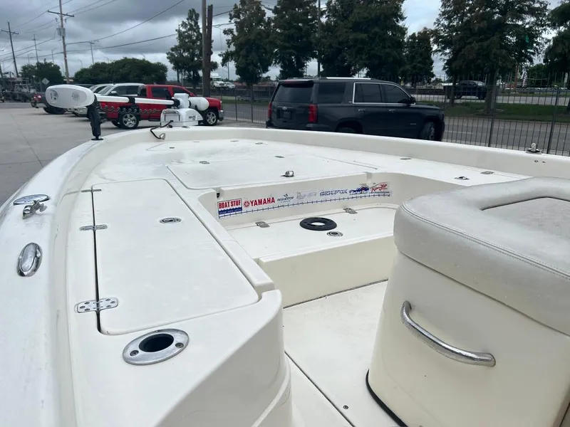 Slide: The Image of 2012 ShearWater 23LTZ boat, white deck, parked near vehicles, overcast day. - 8