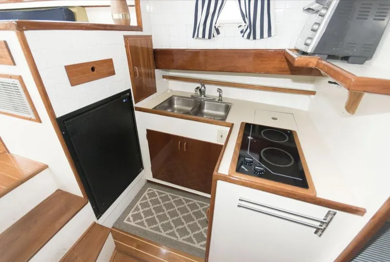 Slide: The Image of Compact 1978 Morton & Hersloff 36 boat kitchen with stove, sink, and wooden accents. - 12