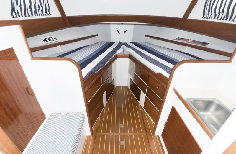 Slide: The Image of 1978 Morton & Hersloff 36 boat interior with striped bedding and wooden cabinetry. - 14