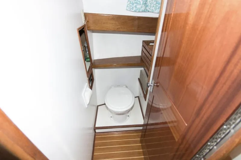 Slide: The Image of Compact wooden boat bathroom with toilet, shelves, and glass door, Morton & Hersloff 36, 1978 model. - 15