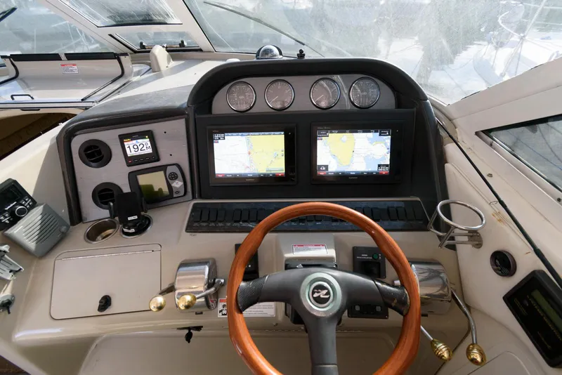Slide: The Image of 2006 Sea Ray 40 Motor Yacht helm with dual navigation screens and wooden steering wheel. - 7
