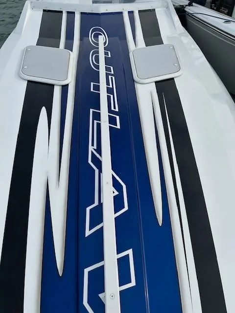 Slide: The Image of 2006 Baja 35 Outlaw boat deck with sleek blue and black design. - 11