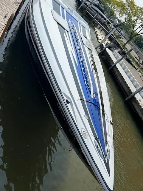 Slide: The Image of 2006 Baja 35 Outlaw speedboat docked in marina, sleek design with blue and white accents. - 16