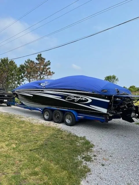 Slide: The Image of 2006 Baja 35 Outlaw speedboat on trailer with blue cover, parked on gravel driveway. - 19