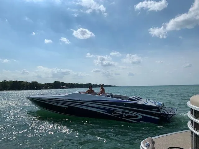 Slide: The Image of 2006 Baja 35 Outlaw speedboat cruising on a sunny lake. - 2