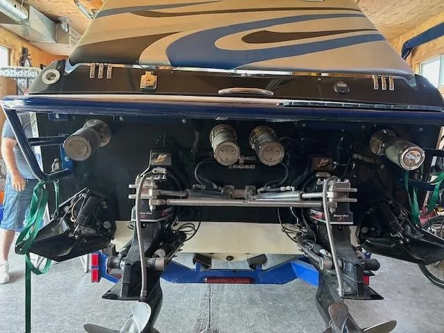 Slide: The Image of 2006 Baja 35 Outlaw boat rear view with dual propellers in a garage setting. - 25