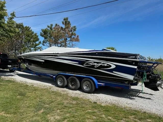 Slide: The Image of 2006 Baja 35 Outlaw speedboat on trailer, black and white design, parked outdoors. - 3