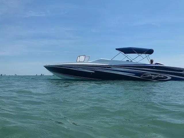 Slide: The Image of 2006 Baja 35 Outlaw speedboat cruising on open water under clear blue skies. - 4