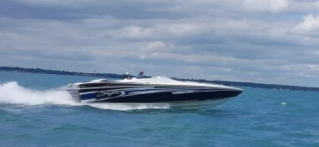 Slide: The Image of 2006 Baja 35 Outlaw speedboat cruising on open water under cloudy skies. - 6