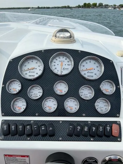 Slide: The Image of Dashboard of 2006 Baja 35 Outlaw boat with gauges and switches, on a lake. - 9
