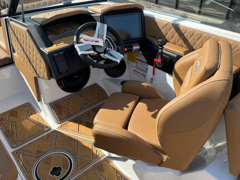 Slide: The Image of 2025 Tigé 22RZX boat interior with tan leather seating and modern dashboard. - 12