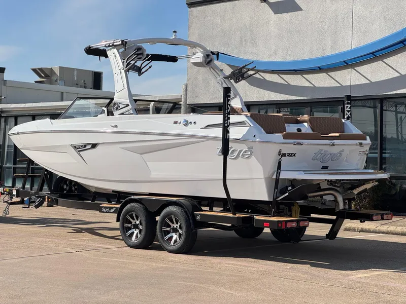 Slide: The Image of 2025 Tigé 22RZX boat on trailer, white exterior, parked outdoors. - 3