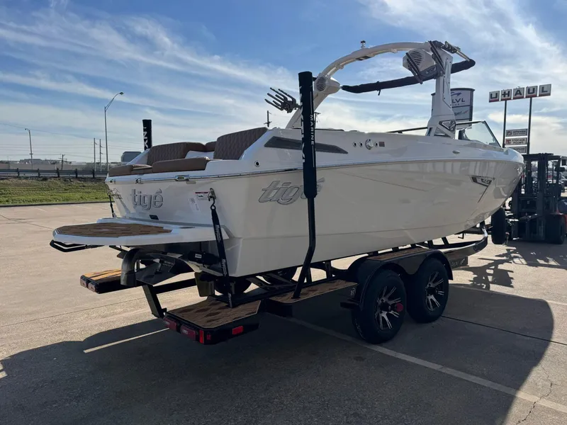 Slide: The Image of 2025 Tigé 22RZX boat on trailer, parked outdoors under clear sky. - 5