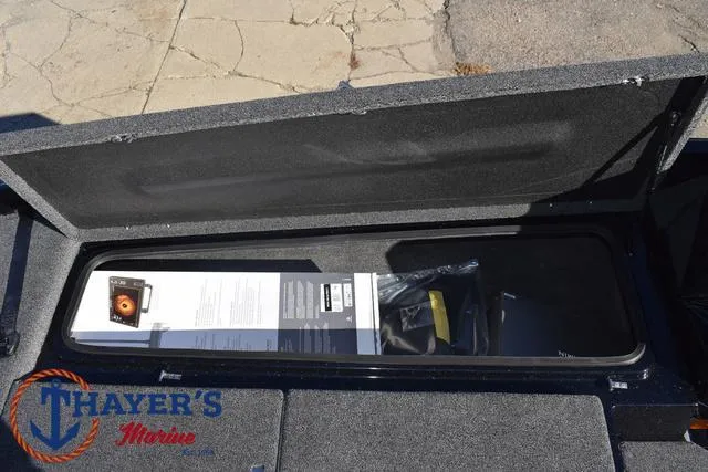 Slide: The Image of Open storage compartment in 2025 Bass Cat Puma STS boat, featuring Thayer's Marine logo. - 15