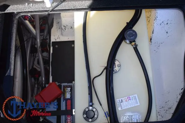 Slide: The Image of 2025 Bass Cat Puma STS boat storage compartment with fuel tank and wiring. - 35