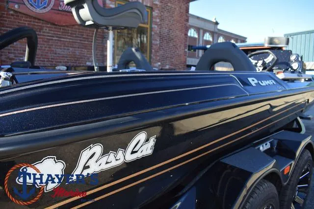 Slide: The Image of 2025 Bass Cat Puma STS boat, sleek black design, parked outdoors. - 43