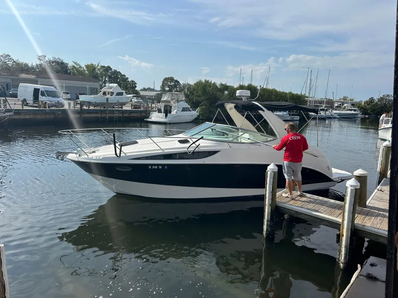 Slide: The Image of 2011 Bayliner 285 Cruiser docked at a marina with a person in a red shirt. - 1