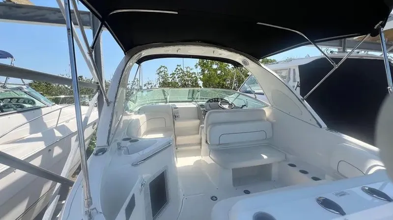 Slide: The Image of 2011 Bayliner 285 Cruiser interior with seating and helm, under canopy. - 10