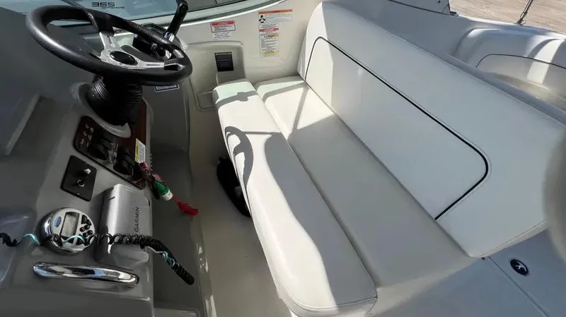 Slide: The Image of 2011 Bayliner 285 Cruiser interior with white seating and steering console. - 15