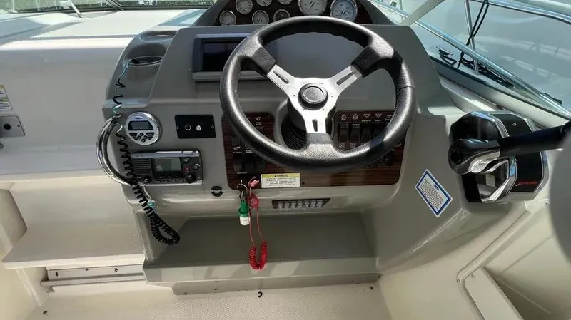 Slide: The Image of 2011 Bayliner 285 Cruiser helm with steering wheel and control panel. - 16