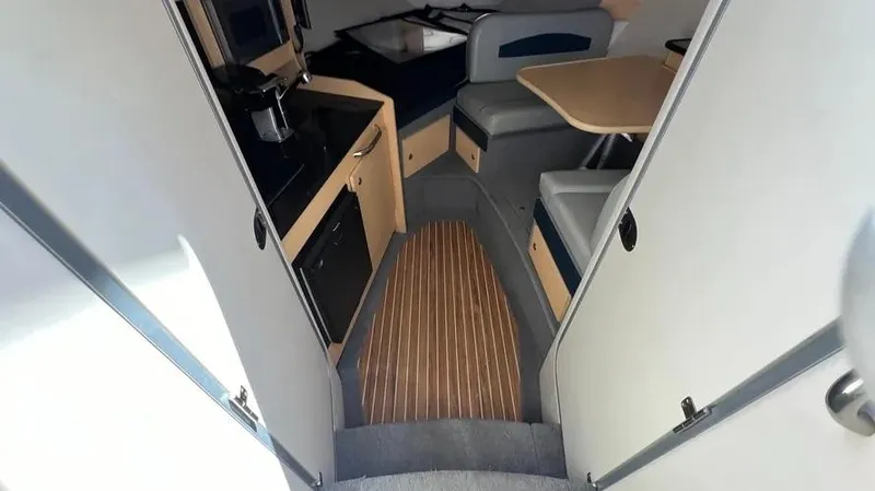 Slide: The Image of Interior of 2011 Bayliner 285 Cruiser with kitchenette and seating area. - 17