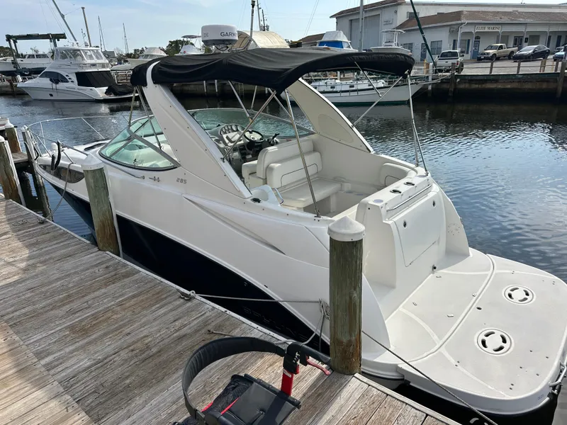 Slide: The Image of 2011 Bayliner 285 Cruiser docked at marina, featuring sleek design and spacious deck. - 2