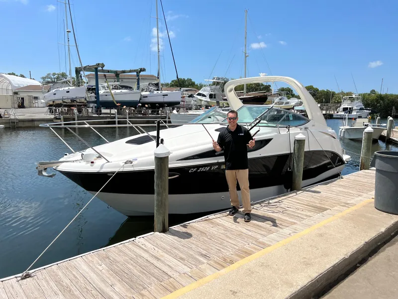 Slide: The Image of 2011 Bayliner 285 Cruiser docked at marina with person standing beside it. - 24