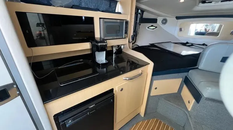 Slide: The Image of Interior of 2011 Bayliner 285 Cruiser with kitchenette and seating area. - 27