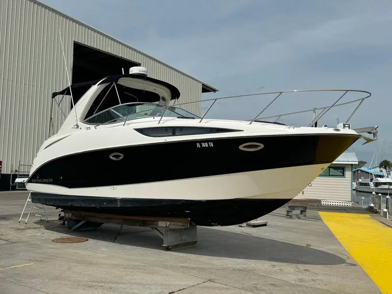 Slide: The Image of 2011 Bayliner 285 Cruiser boat on dry dock near a marina. - 3