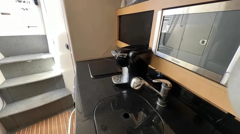 Slide: The Image of 2011 Bayliner 285 Cruiser kitchen with sink, microwave, and coffee maker. - 30