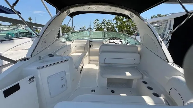 Slide: The Image of 2011 Bayliner 285 Cruiser interior with white seating and helm, under sunny skies. - 33