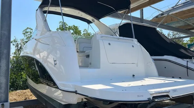 Slide: The Image of 2011 Bayliner 285 Cruiser boat with sleek white exterior, docked under shelter. - 35