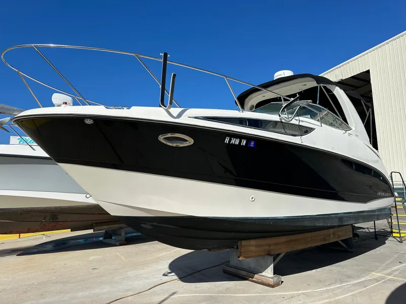 Slide: The Image of 2011 Bayliner 285 Cruiser boat on dry dock under clear blue sky. - 43