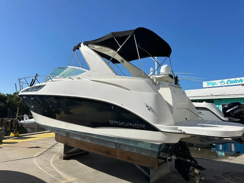 Slide: The Image of 2011 Bayliner 285 Cruiser boat on display under clear blue sky. - 44