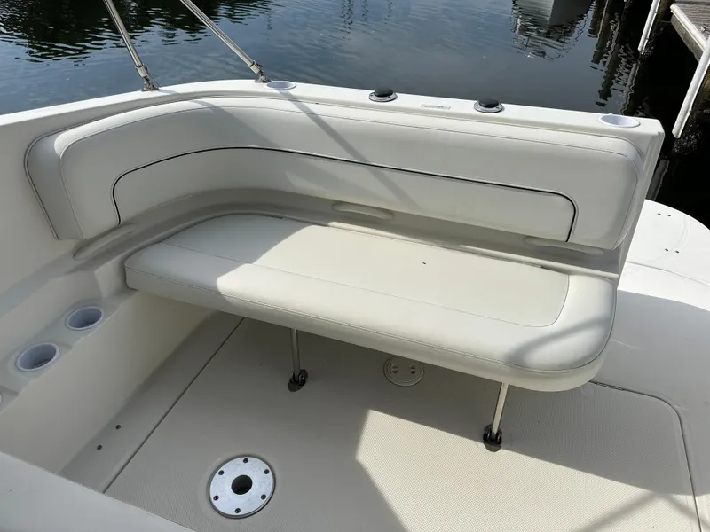 Slide: The Image of 2011 Bayliner 285 Cruiser interior seating area with white upholstery and cup holders. - 9