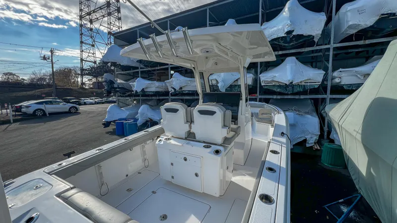 Slide: The Image of 2022 Pursuit S 268 Sport boat in storage, showcasing spacious deck and seating. - 11