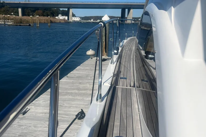 Slide: The Image of Azimut 40 Flybridge 2013 yacht docked by a wooden pier, with a scenic bridge view. - 21
